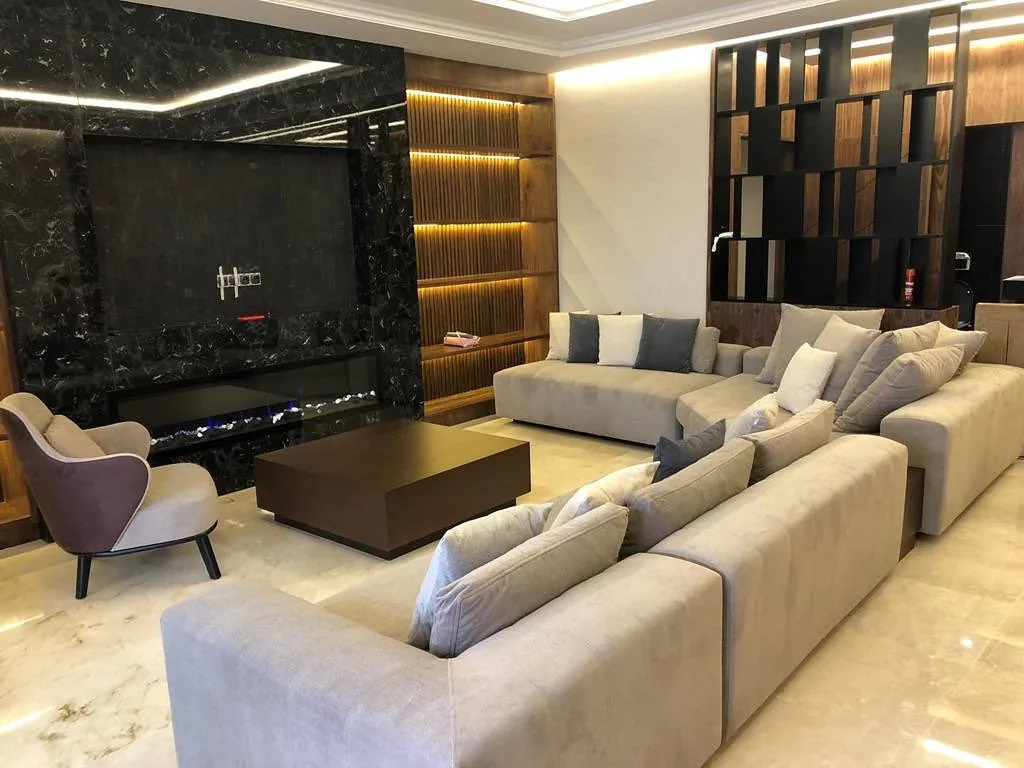Grand séjour avec mur TV en marbre noir et rangements en bois